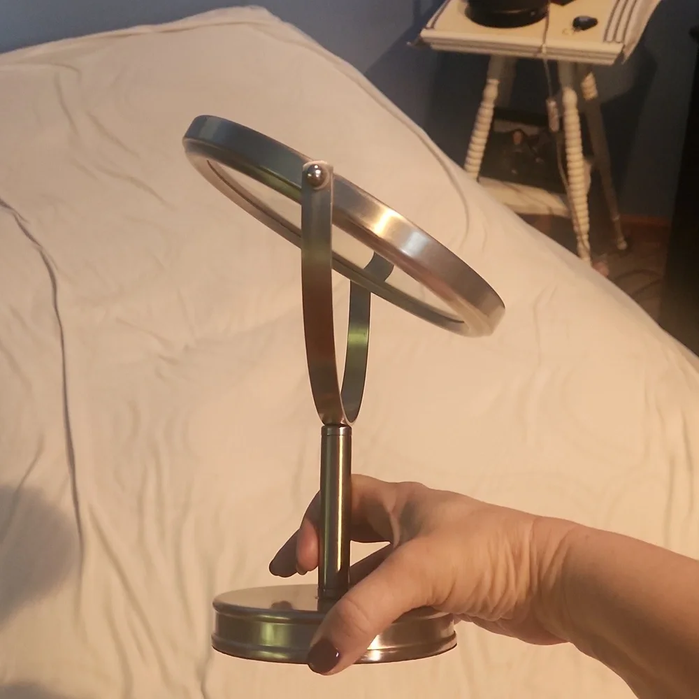 Double-sided vanity mirror, one side magnified. Silver frame